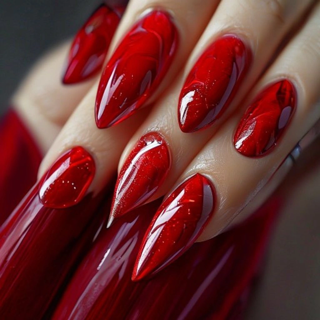 Close-up of stiletto nails with a velvety matte red base, featuring glossy red tulip outlines painted on top that catch the light. Modern, high-contrast studio lighting.